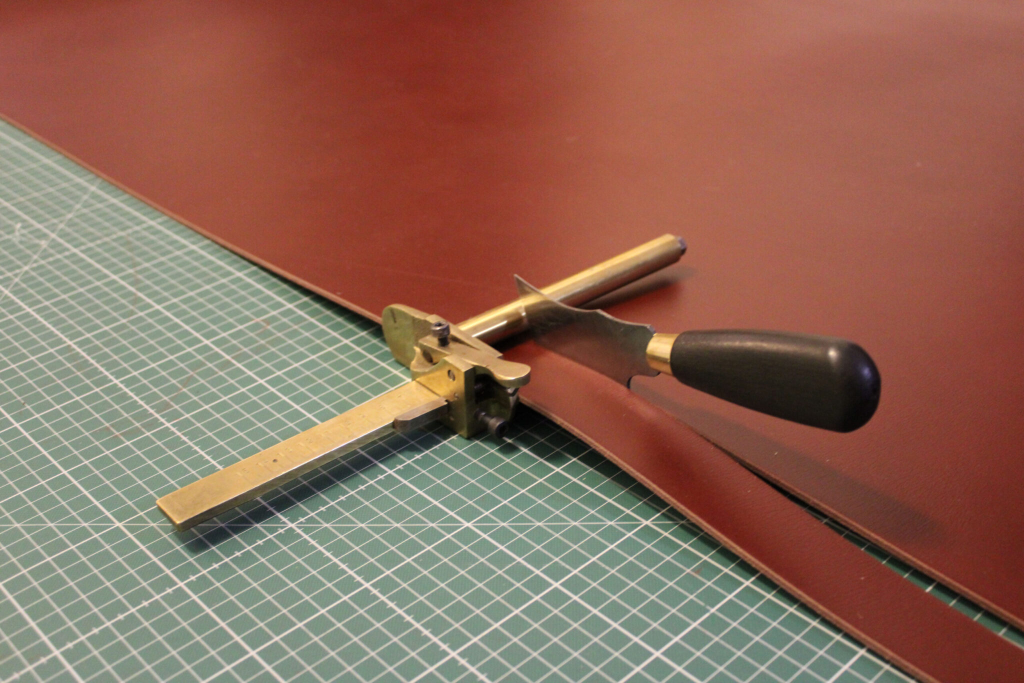 Image of the process for hand cutting a strap from a leather hide